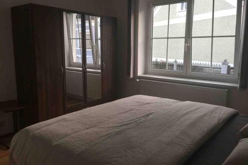 a bed in a bedroom with two windows at HAUS mit 3 Schlafzimmer und Garten in Amstetten
