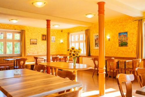 um restaurante com mesas e cadeiras e paredes amarelas em Hotel-Pension Eschwege em Eschwege