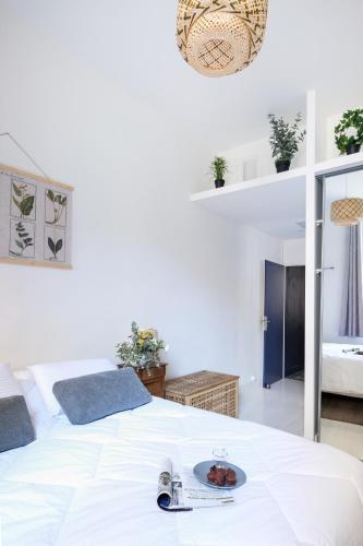 - un lit blanc avec une assiette de nourriture dans l'établissement trendy flat-lyon centre-hotel de ville, à Lyon