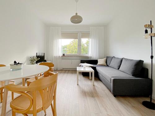 een woonkamer met een bank en een tafel bij Gemütliche Ferienwohnung für bis zu 6 Personen im Stadtzentrum in Bremerhaven