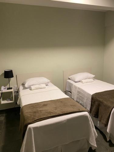 dos camas sentadas una al lado de la otra en una habitación en Hotel Onda Azul, en Valença
