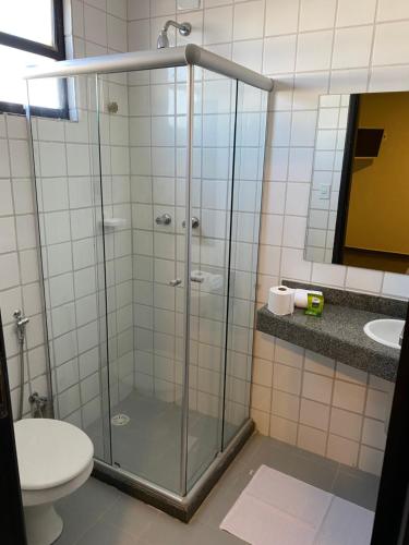 a bathroom with a shower with a toilet and a sink at Hotel Onda Azul in Valença