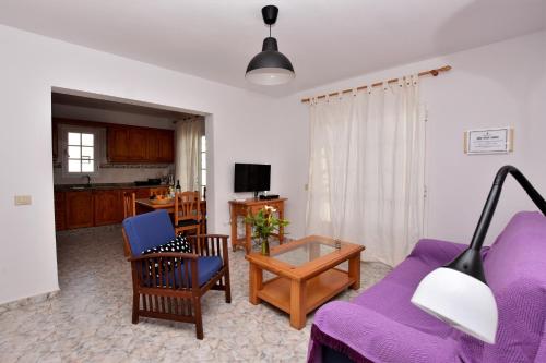 een woonkamer met een paarse bank en stoelen bij Mar y Sol Terraces Sea Views in Punta de Mujeres