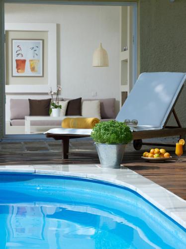 a blue swimming pool in a living room with a couch at Atrium Hotel in Agia Paraskevi