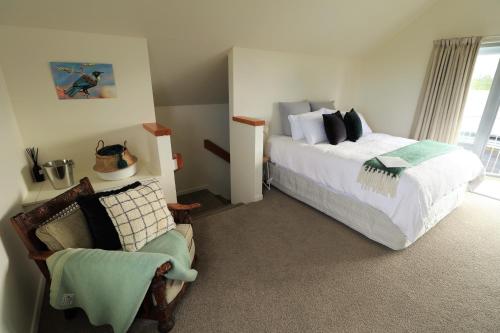 ein Schlafzimmer mit einem Bett und einem Stuhl in der Unterkunft Le Grá Vineyard and Winery in Masterton