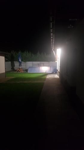a tennis court lit up at night with a light at Wellness Villa Diana in Boldogkőváralja
