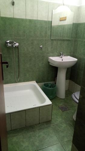 a bathroom with a sink and a bath tub and a sink at La Conu Iancu in Drobeta-Turnu Severin