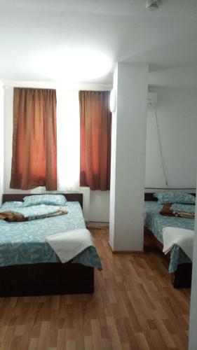 a bedroom with two beds and a wooden floor at La Conu Iancu in Drobeta-Turnu Severin