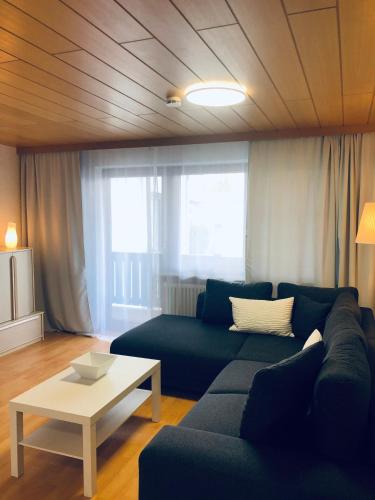 a living room with a blue couch and a table at Ferienwohnungen Hecker in Bad Gögging