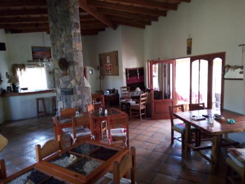 una sala de estar con mesas y sillas de madera. en Hostal El Ensueño del Coquena en San Lorenzo