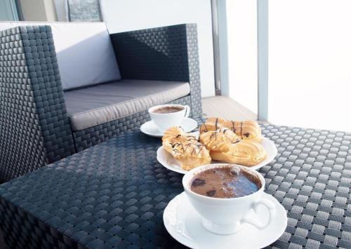 two cups of coffee and two donuts on a table at Apartament Poezja, Kasprowicza 20a in Kołobrzeg