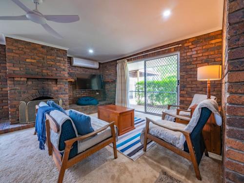 uma sala de estar com uma parede de tijolos em Croydon Ave 50 Currimundi em Kawana Waters