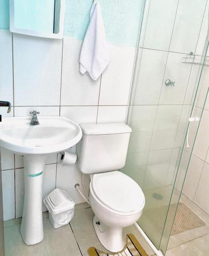 a bathroom with a toilet and a sink at Pousada Cauna in Caraguatatuba