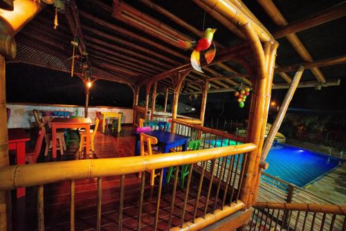 a balcony with a table and chairs and a pool at Eco Hotel las Palmas in Armenia