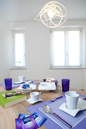a dining room table with a blue napkin and dishes on it at Palazzo Boscareto - suites di charme in centro storico - garage moto, box bici in Corinaldo