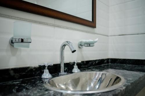 lavabo de plata en un baño con espejo en Aurelia, en Valeria del Mar