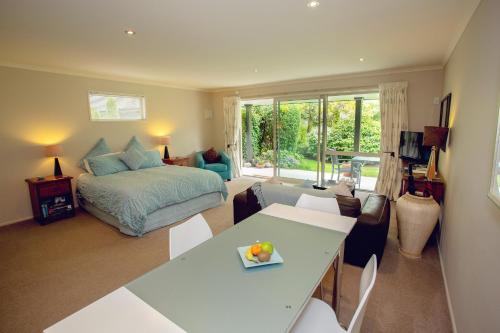 a bedroom with a bed and a living room with a table at Marchmont Gardens in Hanmer Springs