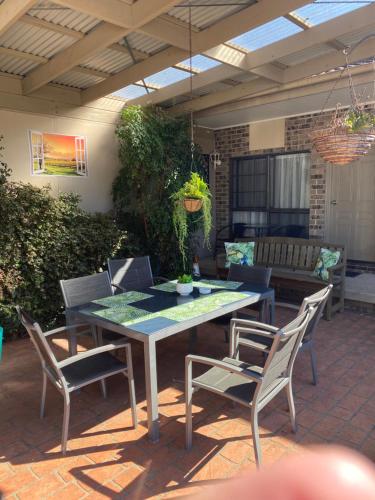 een patio met een tafel en stoelen bij Marriott Park Motel in Nowra