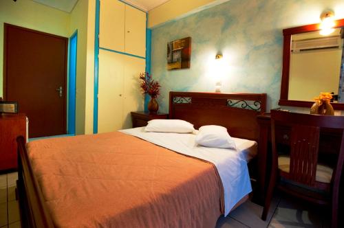 un dormitorio con una cama, un escritorio y un espejo en Pergamos Hotel, en Atenas