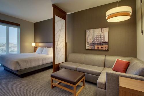 a hotel room with a bed and a couch at Hyatt Place Milwaukee Downtown in Milwaukee