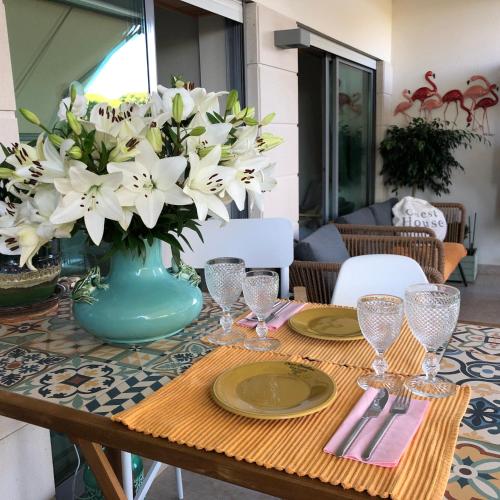 a table with a vase of white flowers on it at Pinetops holidays Apartment in Albufeira