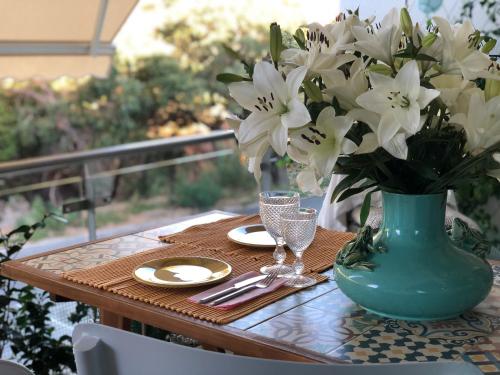 a table with a vase with white flowers on it at Pinetops holidays Apartment in Albufeira