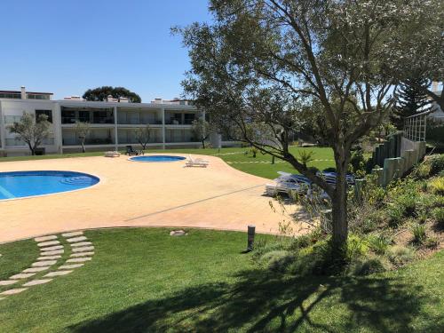a yard with a swimming pool and a building at Pinetops holidays Apartment in Albufeira