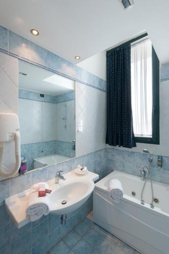 a bathroom with a sink and a tub and a mirror at Hotel Le Sorgenti in Bolzano Vicentino