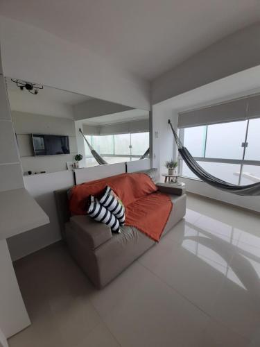 ein Wohnzimmer mit einem Sofa und einigen Fenstern in der Unterkunft Apto com vista deslumbrante, com piscina e garagem! in Balneário Camboriú