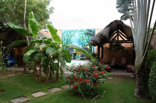 a garden with a gazebo and some flowers at Hotel Aurore Lomé in Lomé