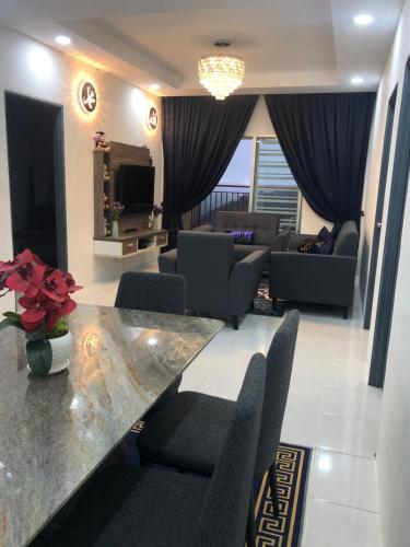 un soggiorno con divano, tavolo e sedie di Ramadhina Eagle Eye View Home2stay Emerald Avenue a Brinchang