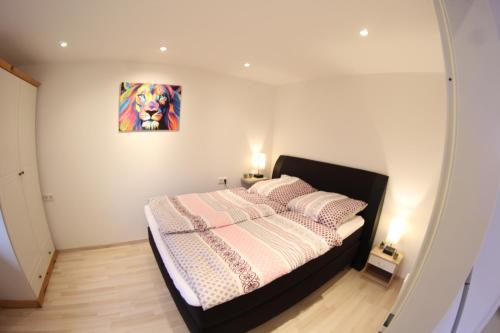 1 dormitorio con 1 cama con una pintura en la pared en Ferienwohnung MoinMoin 2D, en Silberstedt