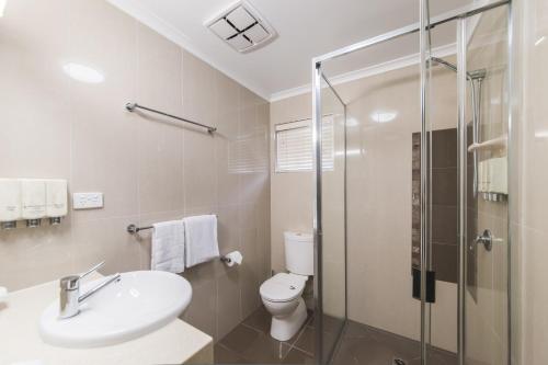 a bathroom with a toilet and a sink and a shower at Apartments on Palmer in Rockhampton