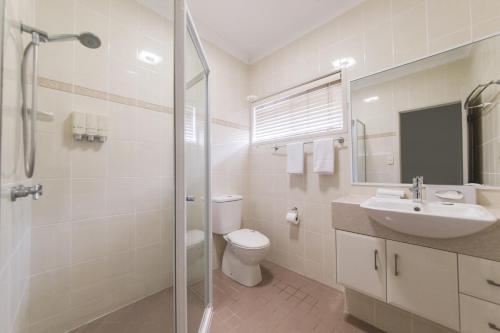 a bathroom with a toilet and a sink and a shower at Apartments on Palmer in Rockhampton