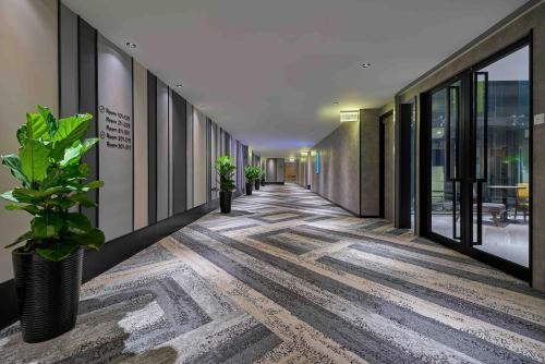 an empty hallway in a building with potted plants at Aerotel Kuala Lumpur (Airport Hotel) - Gateway@klia2 in Sepang
