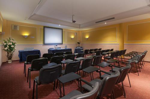 a conference room with chairs and a projection screen at Hotel Le Sorgenti in Bolzano Vicentino