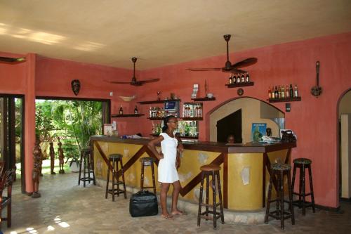 una mujer parada frente a un bar en Hotel Aurore Lomé en Lomé