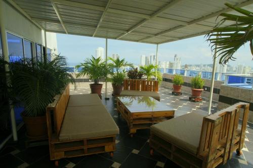 un patio con sillas, mesas y macetas en Apartamentos Bacanos en Cartagena de Indias