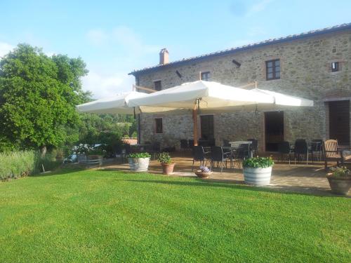 a patio with an umbrella in front of a building at Tenuta Seripa in Sassetta