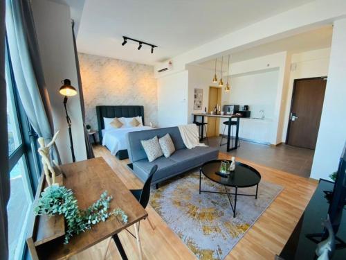 a living room with a blue couch and a bed at Kuantan Imperium by Glex in Kuantan