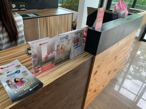 un mostrador con una pantalla de revistas. en RedDoorz at Anton's Loft Designer Resort Pansol Calamba Laguna, en Laguna