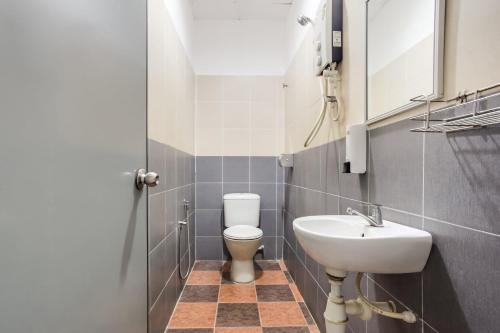 a bathroom with a toilet and a sink at Super OYO 89427 Kavanas Hotel Taiping in Taiping