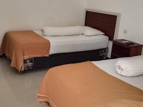 Fidelia Homestay Palu Mitra RedDoorz tesisinde bir odada yatak veya yataklar