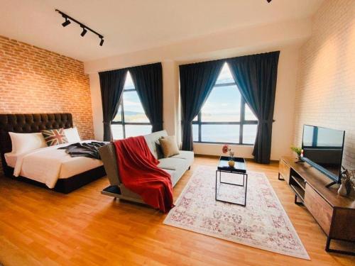 a bedroom with a bed and a couch and a tv at Kuantan Imperium by Glex in Kuantan