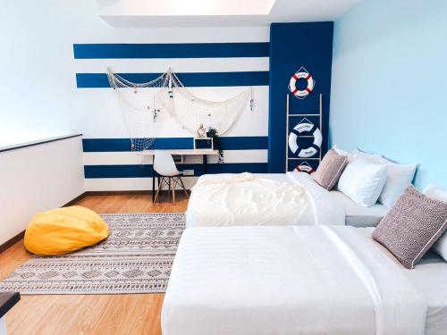 two beds in a room with blue and white stripes at Kuantan Imperium by Glex in Kuantan