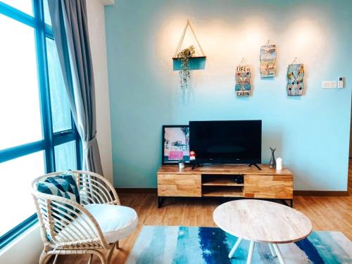 a living room with a flat screen tv and a table at Kuantan Imperium by Glex in Kuantan