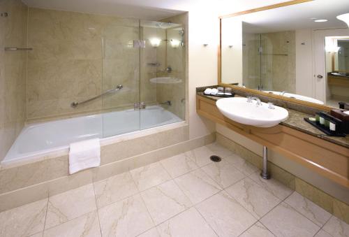 a bathroom with a tub and a sink and a shower at Stamford Plaza Sydney Airport Hotel & Conference Centre in Sydney