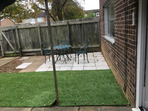 a garden with a table and chairs on a patio at Pendleton in Peterborough