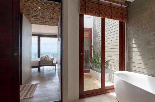 ein Badezimmer mit Badewanne und Blick auf das Meer in der Unterkunft Chula Beach Resort in Khanom