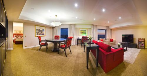 a living room with a red couch and a table at Stamford Plaza Sydney Airport Hotel & Conference Centre in Sydney
